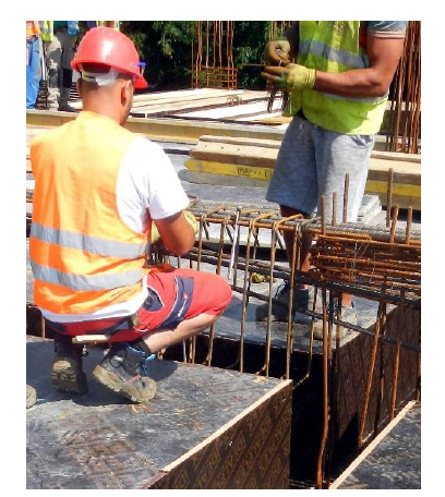 Lucrător aflat într-o poziție joasă în timpul unei activități din construcții